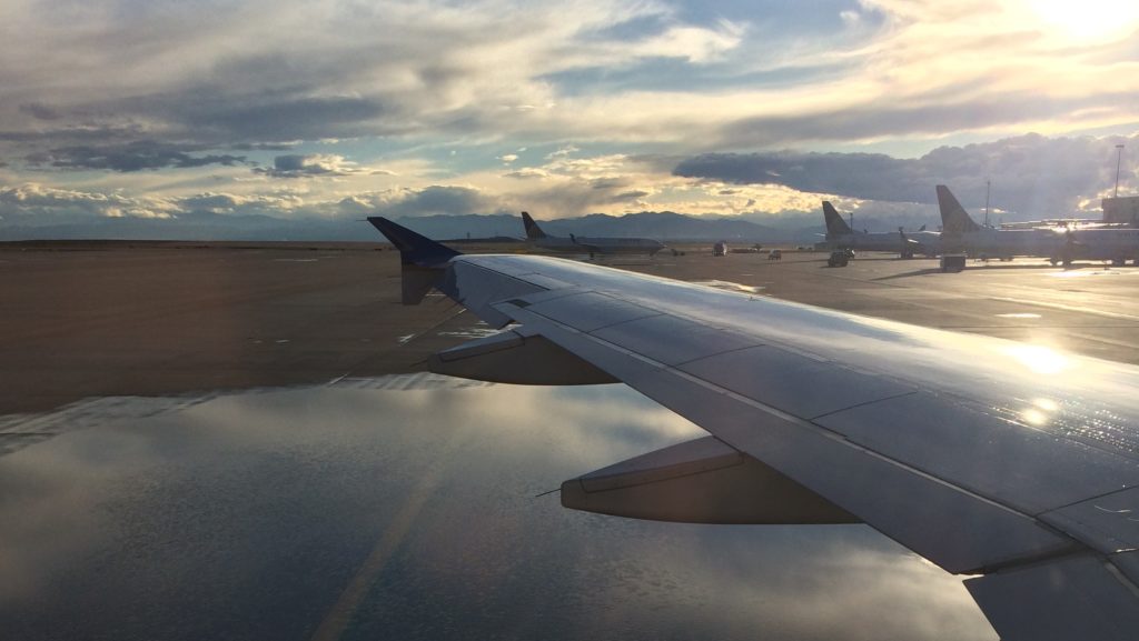 planes on the runway reflected in a puddle